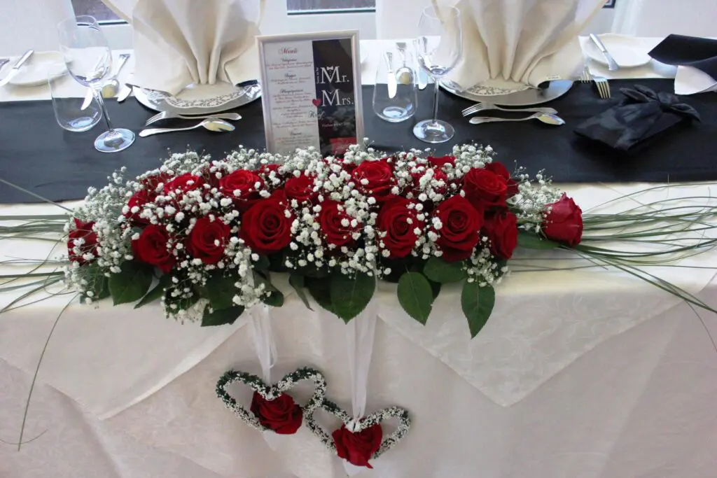 Tischgesteck mit roten Rosen